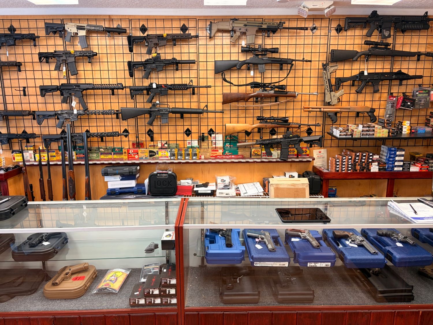 Inside Chuck's Guns & Ammo — rifle wall, ammunition shelves, and pistol counter